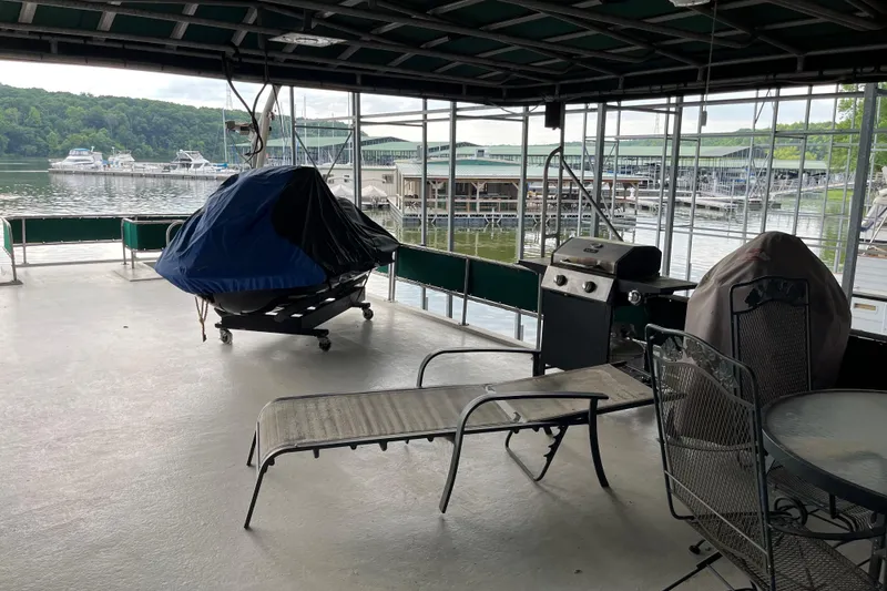 Slide: The Image of Covered deck on a 1997 Lakeview 65x18 houseboat with grill and seating, overlooking marina. - 18