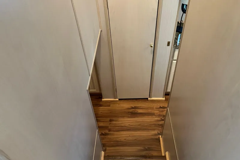 Slide: The Image of Narrow hallway with wooden flooring in a 1997 Lakeview 65x18 model. - 14