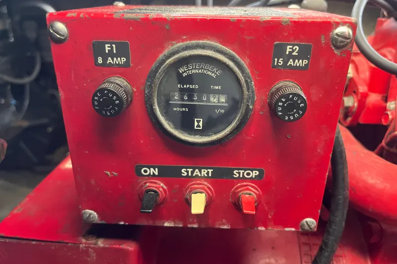 Slide: The Image of Red control panel with Westerbeke hour meter, fuses, and start/stop buttons on a Lakeview 65x18. - 35