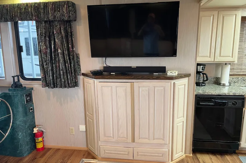 Slide: The Image of Interior of a 1997 Lakeview 65x18 houseboat with TV, cabinets, and kitchen appliances. - 10