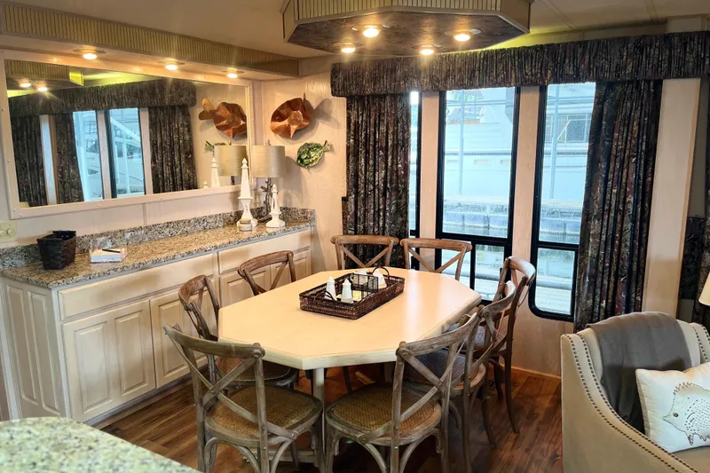 Slide: The Image of Dining area in a 1997 Lakeview 65x18 houseboat with elegant decor and large windows. - 7