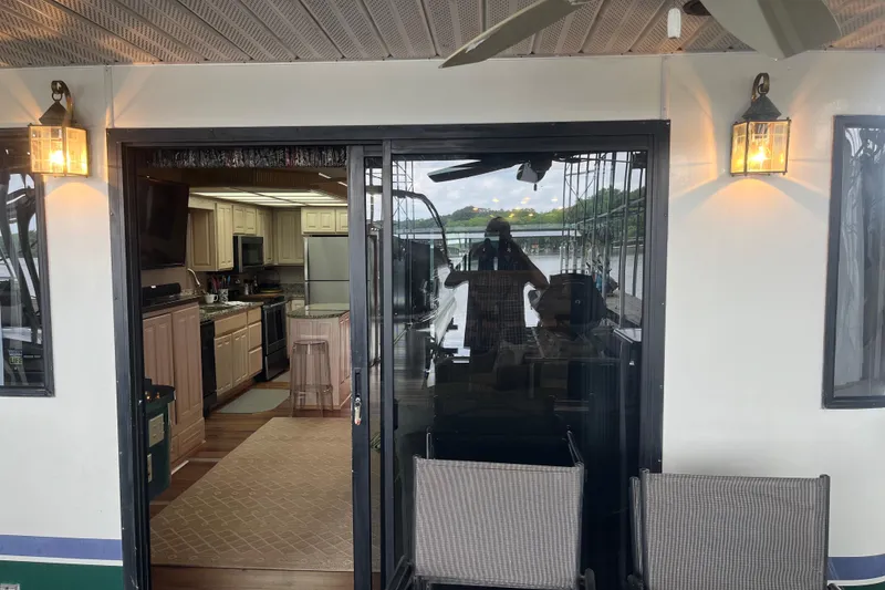 Slide: The Image of Houseboat interior view with kitchen, Lakeview 65x18 model, 1997, featuring outdoor seating and lighting. - 4