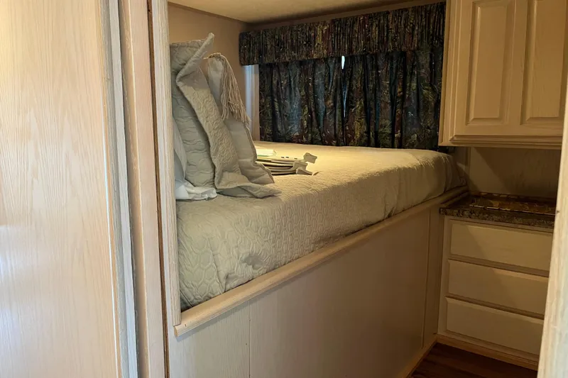 Slide: The Image of Cozy bedroom in 1997 Lakeview 65x18 houseboat with wood cabinetry and patterned curtains. - 11