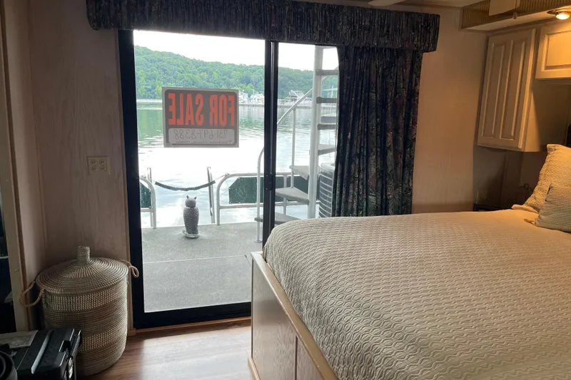 Slide: The Image of Bedroom view inside 1997 Lakeview 65x18 houseboat, with "For Sale" sign on sliding door. - 17