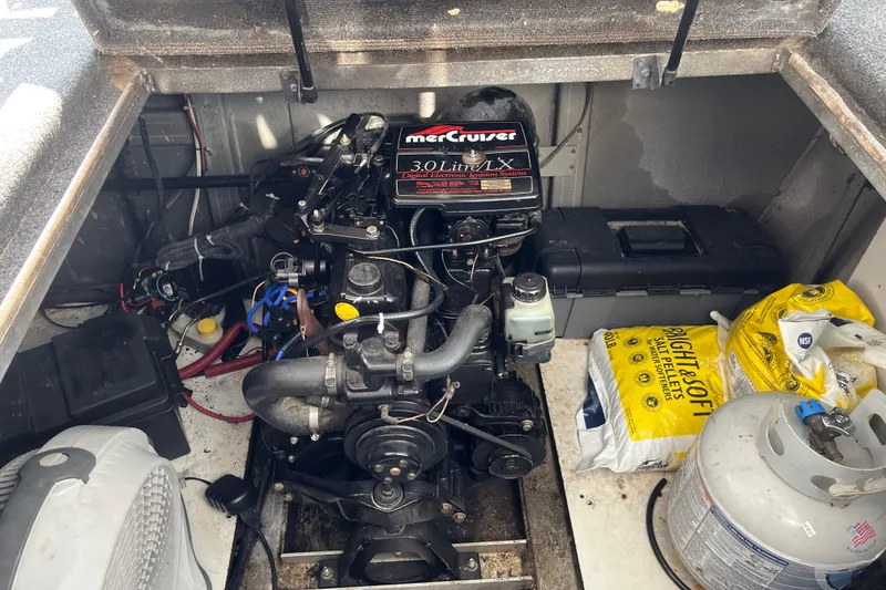 Slide: The Image of Engine compartment of a 1997 Lakeview 65x18 with MerCruiser 3.0L motor and storage items. - 33