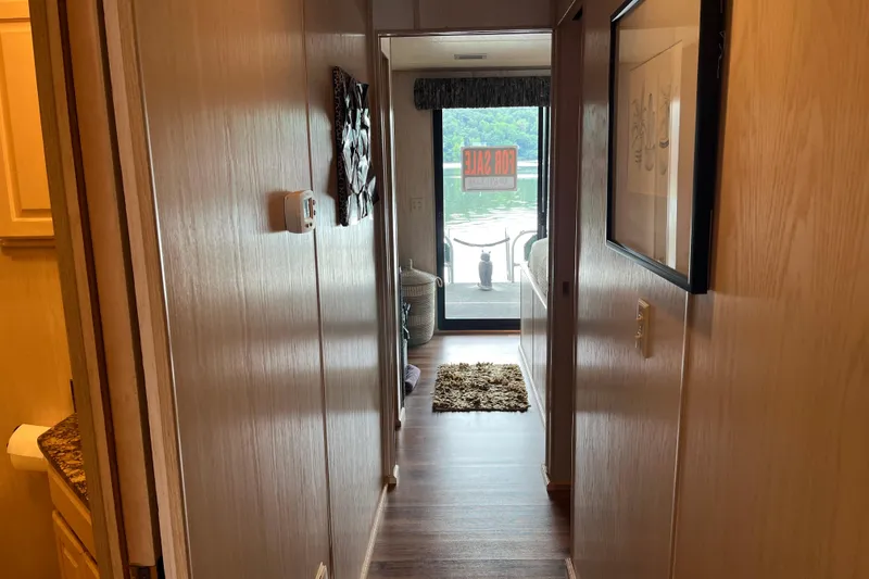 Slide: The Image of Hallway view inside 1997 Lakeview 65x18 houseboat, featuring a "For Sale" sign. - 13