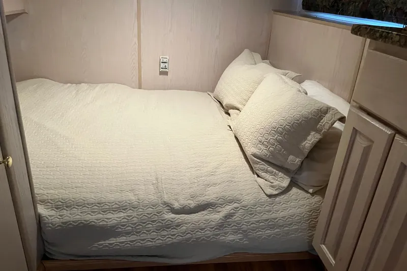 Slide: The Image of Cozy bedroom in 1997 Lakeview 65x18 houseboat with elegant bedding and wooden cabinetry. - 16