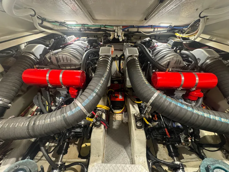 Slide: The Image of The engine room of a 2002 Pursuit 3000 Express with two large engines and red components. - 34