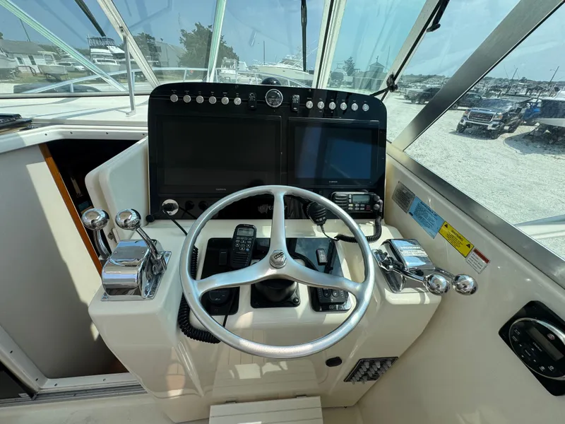 Slide: The Image of The image shows the helm of a 2002 Pursuit 3000 Express boat with modern instruments. - 14