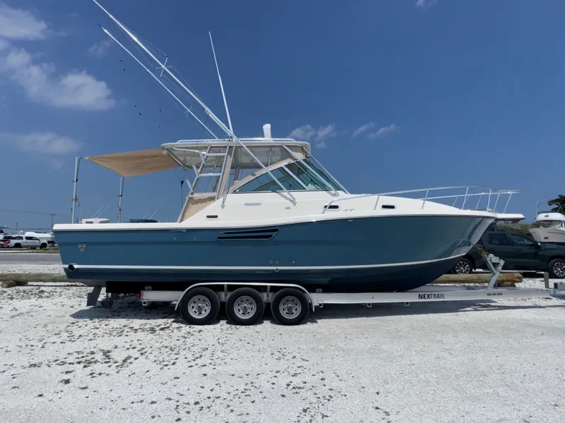 Slide: The Image of A 2002 Pursuit 3000 Express boat is on a trailer on land. - 9