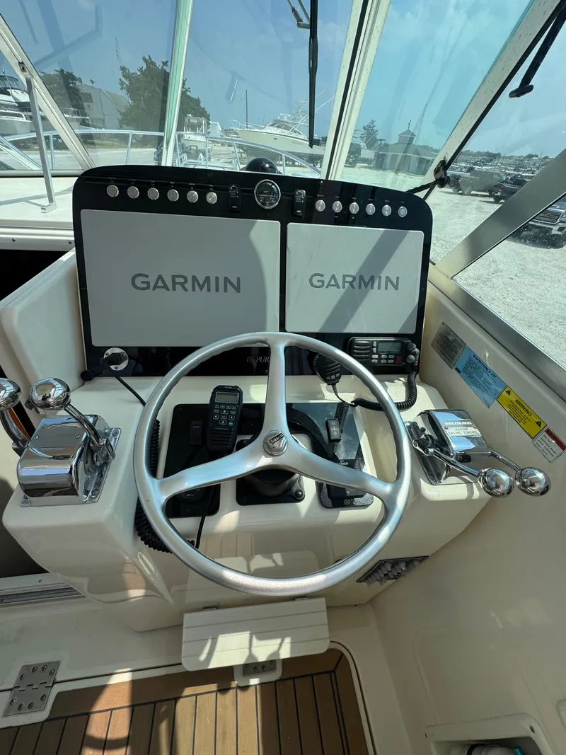 Slide: The Image of Helm of the Pursuit 3000 Express with Garmin screens and wooden deck. - 13