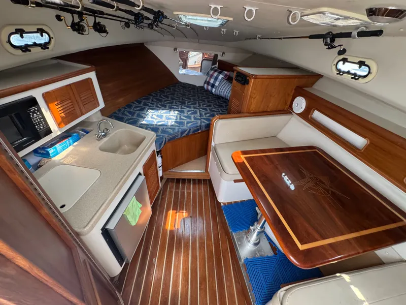 Slide: The Image of Interior of a 2002 Pursuit 3000 Express with kitchen, table, and sleeping area. - 24