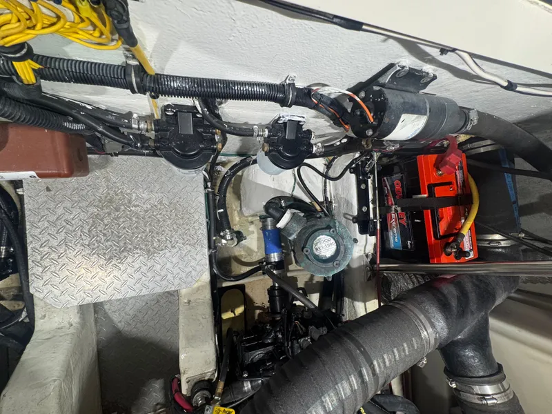 Slide: The Image of Engine room of a Pursuit 3000 Express with cables, batteries, and mechanical components. - 37