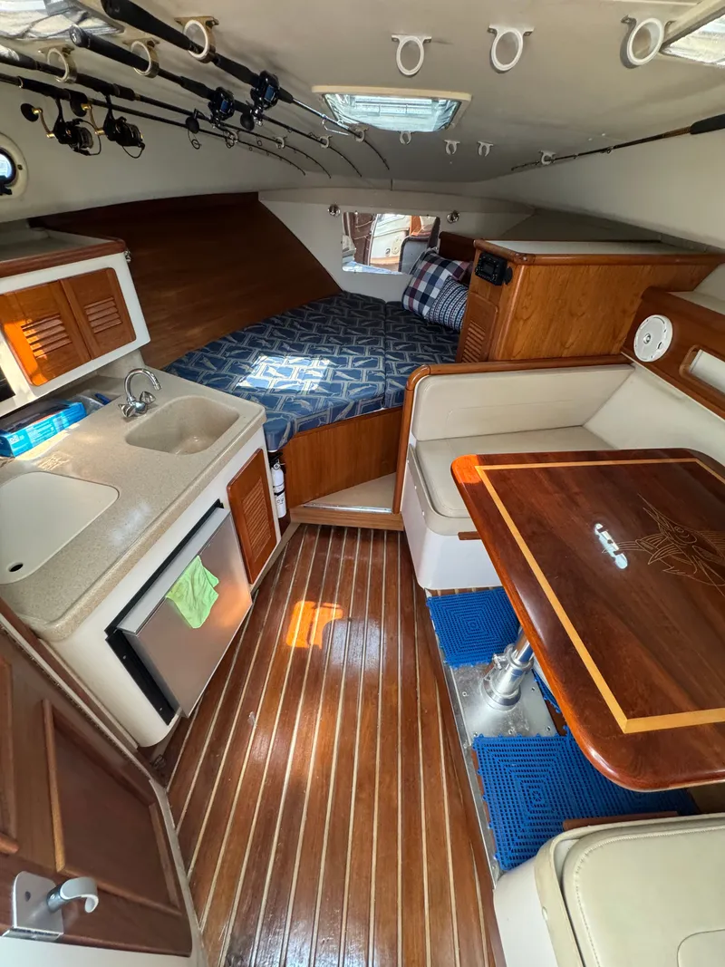 Slide: The Image of Interior of a 2002 Pursuit 3000 Express with kitchen, table, and sleeping area. - 23