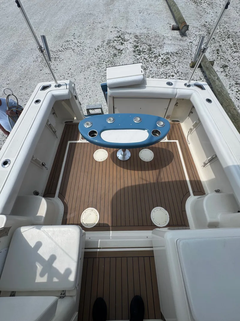 Slide: The Image of The image shows the cockpit of a 2002 Pursuit 3000 Express boat with wood flooring and a blue table. - 16