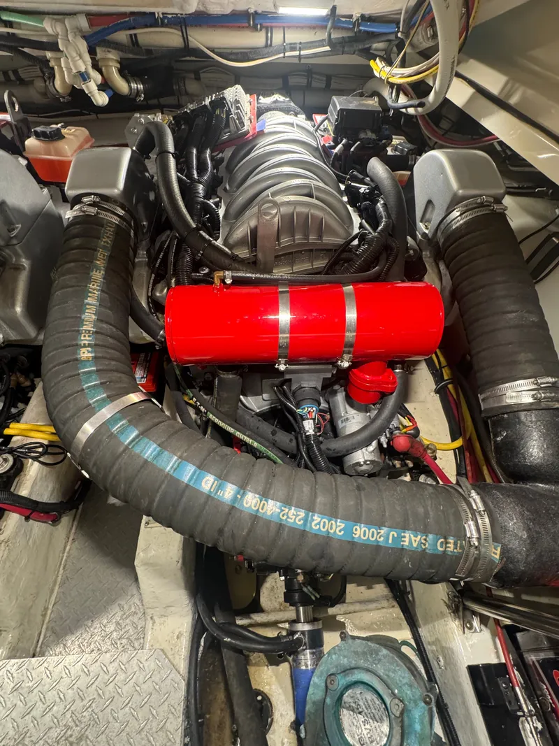 Slide: The Image of Engine room of a 2002 Pursuit 3000 Express with visible engine and hoses. - 35