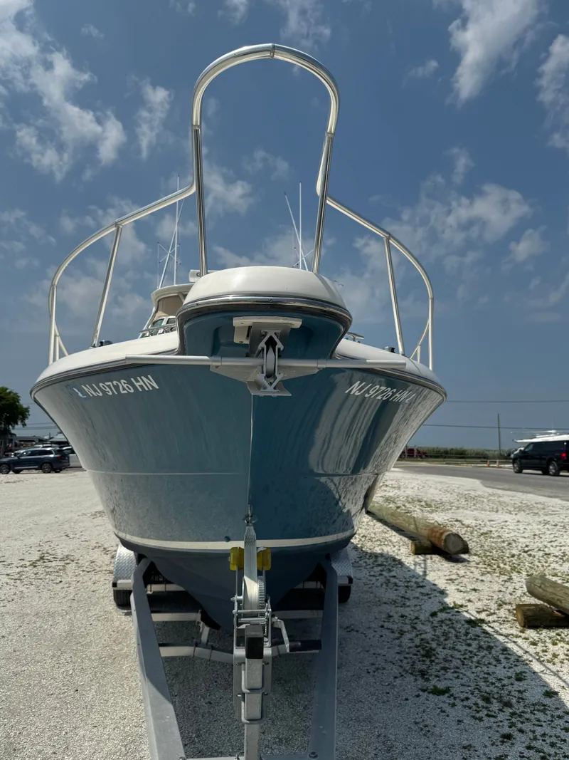 Slide: The Image of A 2002 Pursuit 3000 Express on a trailer, featuring a blue hull and white deck. - 7
