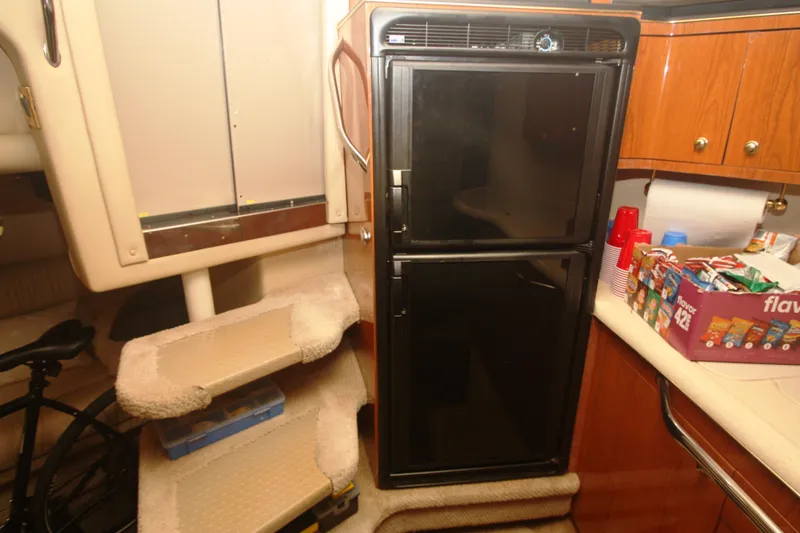 Slide: The Image of Interior of 1999 Sea Ray 380 Sundancer with fridge, snacks, and carpeted steps. - 50