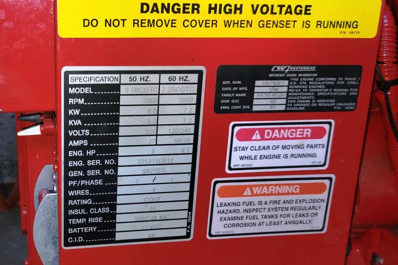 Slide: The Image of Warning labels and specifications on a red generator for a 1999 Sea Ray 380 Sundancer. - 76