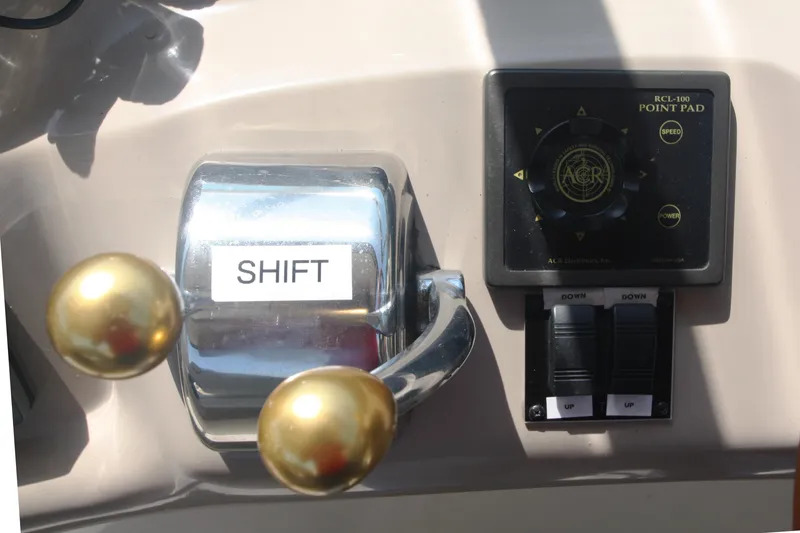 Slide: The Image of Control panel of a 1999 Sea Ray 380 Sundancer boat with shift lever and point pad. - 28