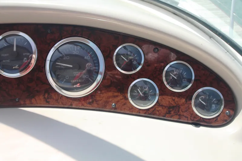 Slide: The Image of Dashboard of a 1999 Sea Ray 380 Sundancer with multiple gauges and wood paneling. - 25