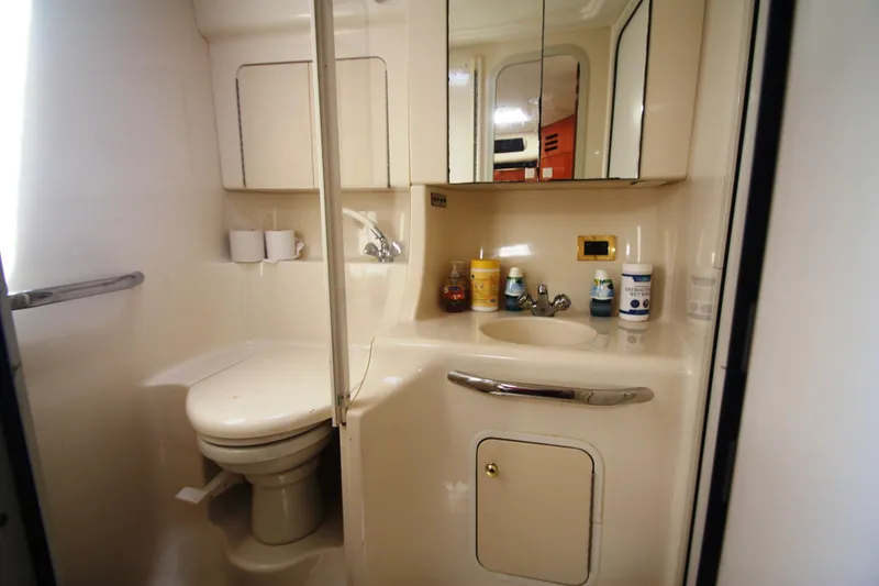 Slide: The Image of 1999 Sea Ray 380 Sundancer bathroom with sink, toilet, and toiletries. - 57