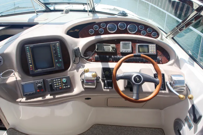 Slide: The Image of Cockpit of 1999 Sea Ray 380 Sundancer with steering wheel and navigation controls. - 22