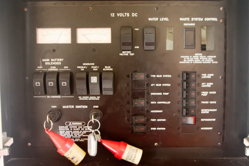 Slide: The Image of Control panel of a 1999 Sea Ray 380 Sundancer boat with various switches and gauges. - 69
