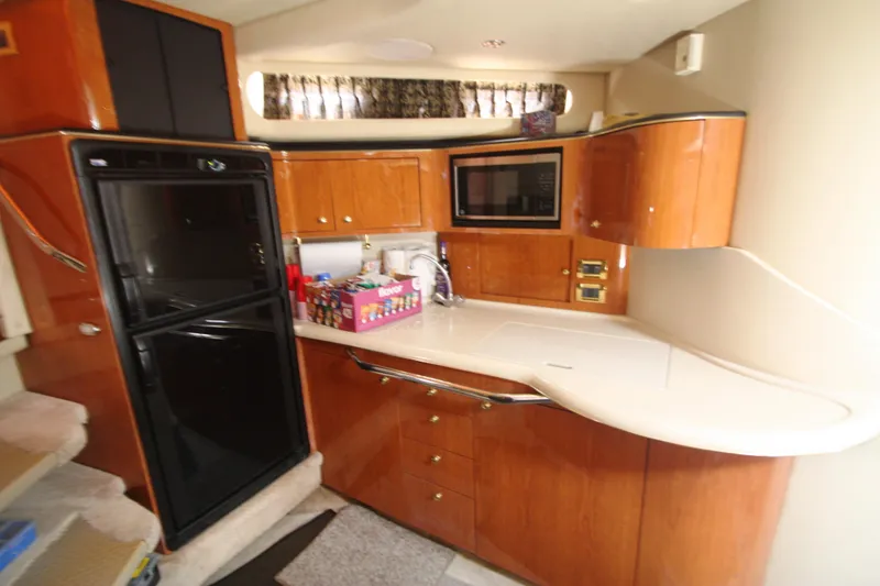 Slide: The Image of Luxurious 1999 Sea Ray 380 Sundancer yacht kitchen with wood cabinetry and modern appliances. - 49