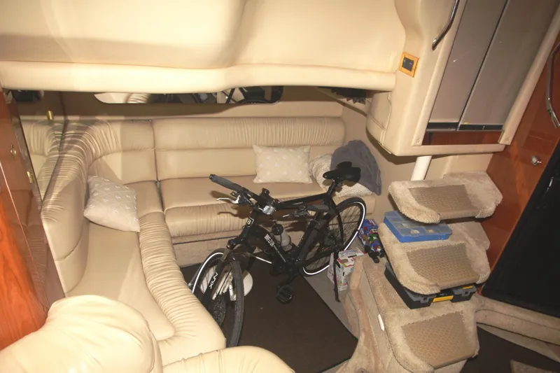 Slide: The Image of Interior of 1999 Sea Ray 380 Sundancer with beige seating and a bicycle. - 56