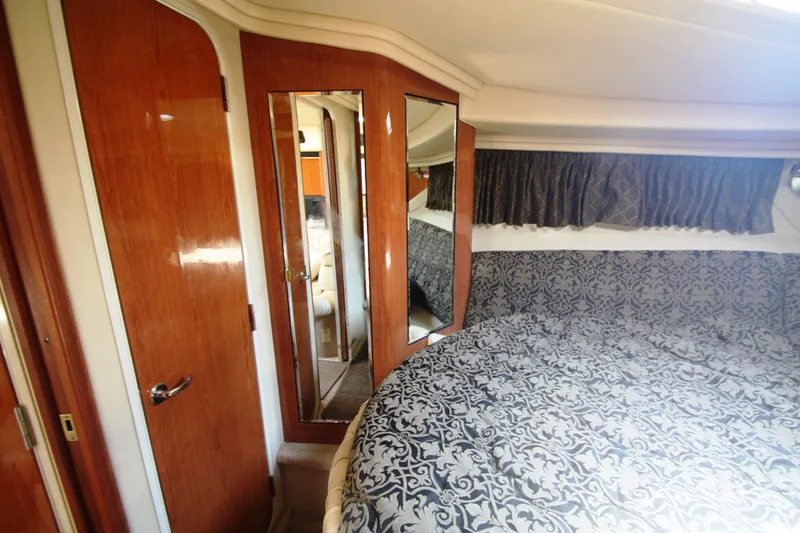 Slide: The Image of Interior cabin of 1999 Sea Ray 380 Sundancer with elegant wood finish and patterned bedding. - 54