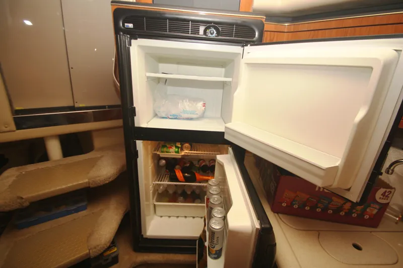 Slide: The Image of Open refrigerator inside 1999 Sea Ray 380 Sundancer yacht, stocked with beverages and ice. - 51
