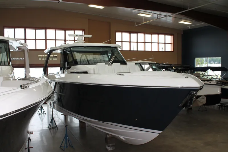 Slide: The Image of 2027 Tiara Yachts 46 LS luxury boat displayed in a showroom. - 1