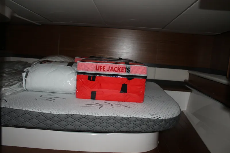 Slide: The Image of Interior cabin of 2027 Tiara Yachts 46 LS with life jackets on bed. - 11