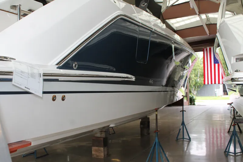 Slide: The Image of 2027 Tiara Yachts 46 LS in showroom, side view with American flag in background. - 16