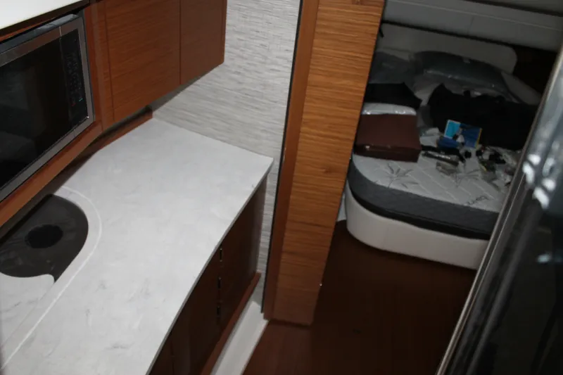 Slide: The Image of Interior of 2027 Tiara Yachts 46 LS, featuring a compact kitchen and cozy sleeping area. - 9