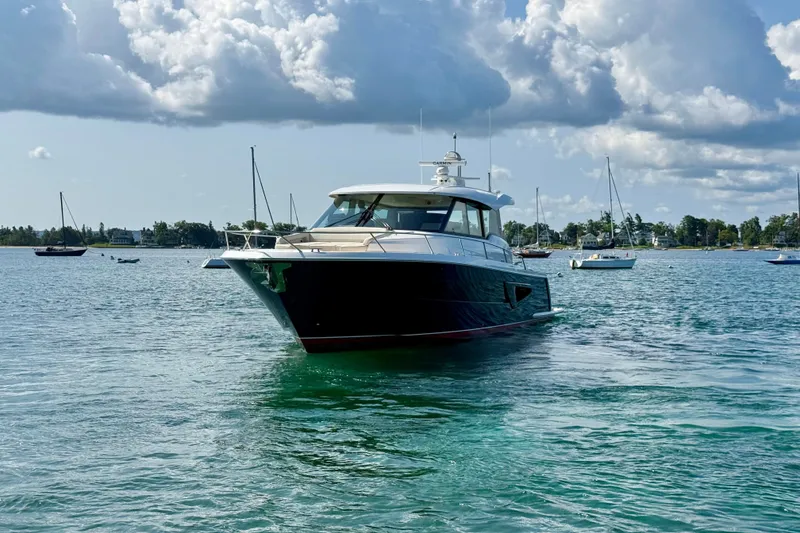 Slide: The Image of 2027 Tiara Yachts EX 54 cruising on a serene, scenic waterway. - 9