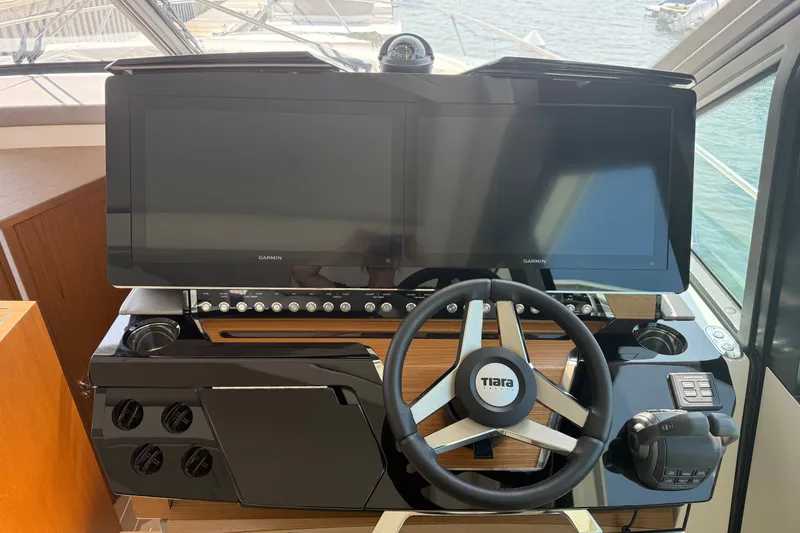 Slide: The Image of Helm of 2027 Tiara Yachts EX 54 with dual Garmin displays and steering wheel. - 19