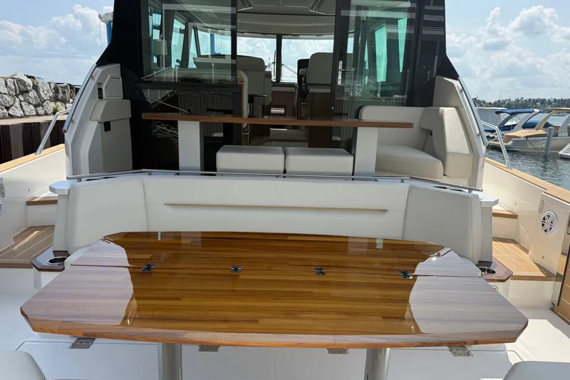 Slide: The Image of 2027 Tiara Yachts EX 54 luxury yacht interior with polished wood table and seating area. - 48