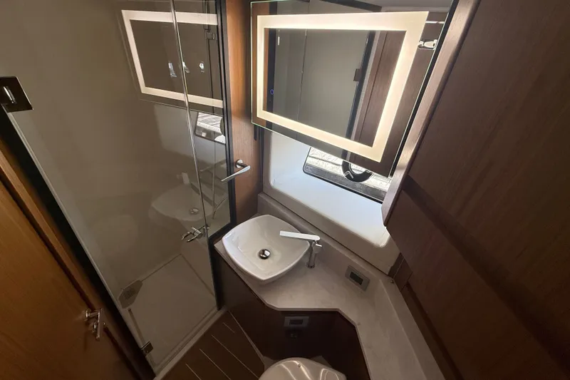 Slide: The Image of Luxurious bathroom in 2027 Tiara Yachts EX 54, featuring modern fixtures and illuminated mirror. - 31