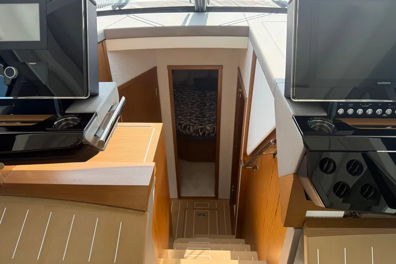 Slide: The Image of Interior view of 2027 Tiara Yachts EX 54, featuring modern navigation equipment and cabin access. - 27