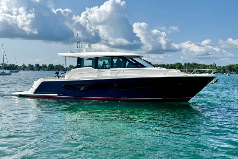 Slide: The Image of 2027 Tiara Yachts EX 54 cruising on clear blue water under a partly cloudy sky. - 7