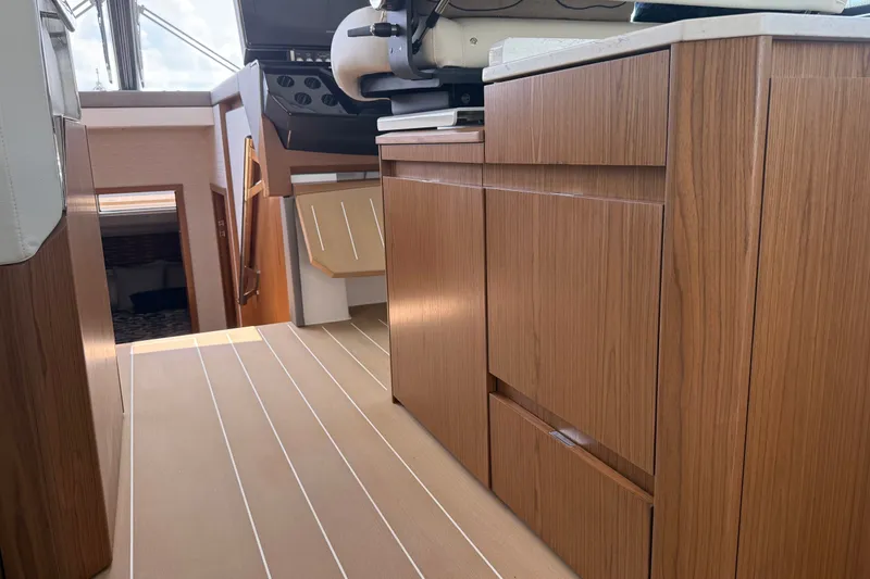 Slide: The Image of Interior of 2027 Tiara Yachts EX 54, featuring sleek wooden cabinetry and modern design. - 26