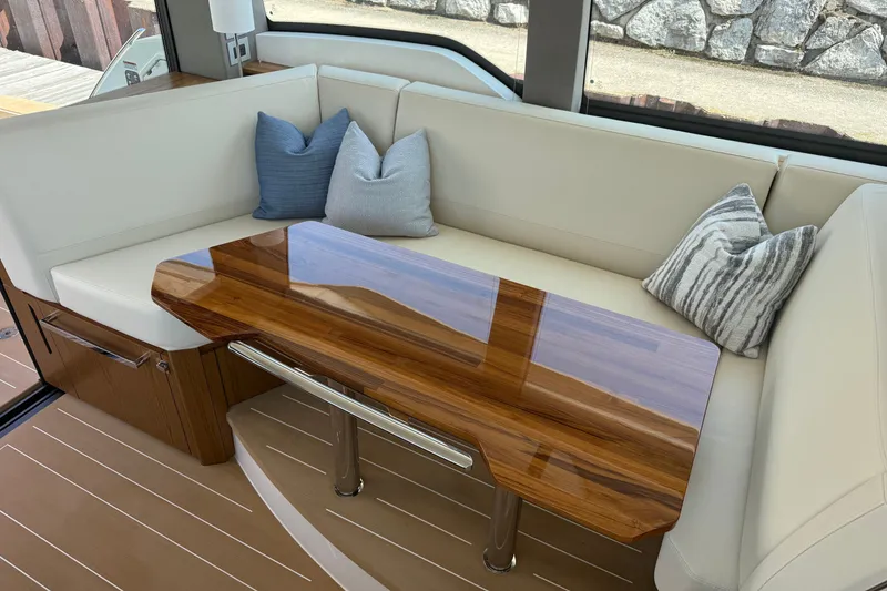 Slide: The Image of Luxurious seating area on 2027 Tiara Yachts EX 54 with elegant wooden table and cushions. - 17