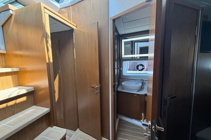 Slide: The Image of Interior of 2027 Tiara Yachts EX 54, featuring wooden stairs and modern bathroom. - 34
