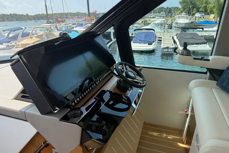 Slide: The Image of Helm of 2027 Tiara Yachts EX 54 with modern controls and marina view. - 14
