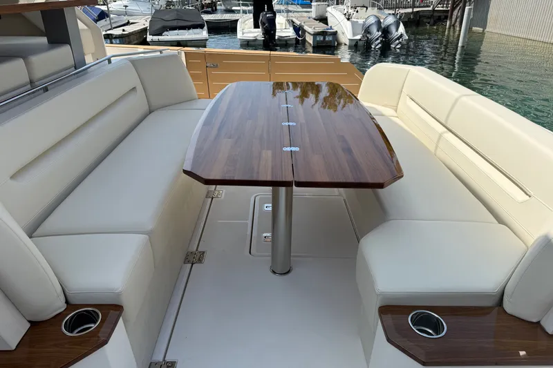 Slide: The Image of Luxurious seating area on 2027 Tiara Yachts EX 54, featuring elegant wood table and cushioned benches. - 55