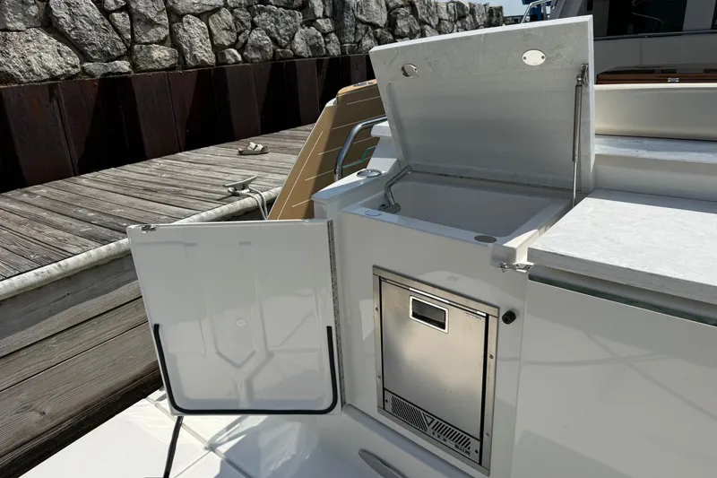 Slide: The Image of Outdoor kitchenette on 2027 Tiara Yachts EX 54, featuring sink and storage. - 60