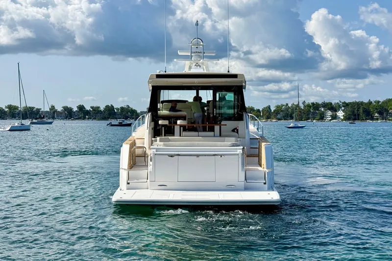 Slide: The Image of 2027 Tiara Yachts EX 54 cruising on a serene lake under a cloudy sky. - 5