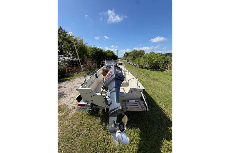 Slide: The Image of Boston Whaler 17 Montauk 1987 boat with Yamaha outboard motor on grassy area. - 2